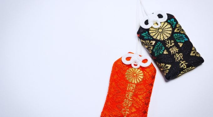 Zwei japanische Omamori in orange und schwarzGlücksbringer Anhänger