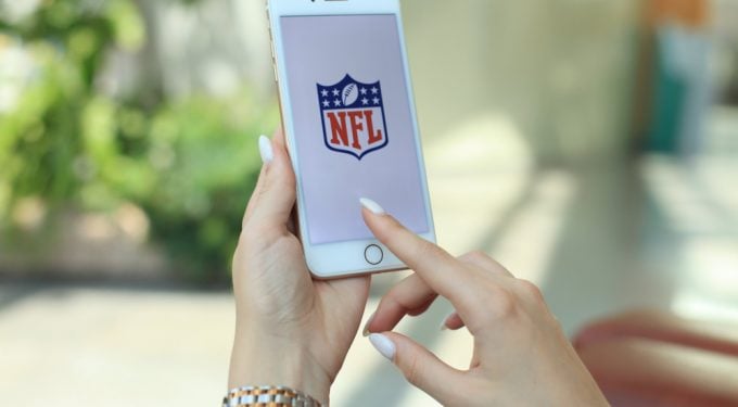 Frauenhand hält Iphone und ruft NFL bei Instagram auf