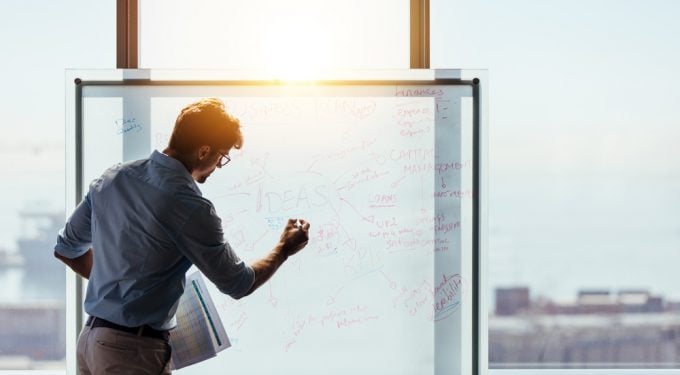 Unternehmer gibt Präsentation im Büro vor Whiteboard