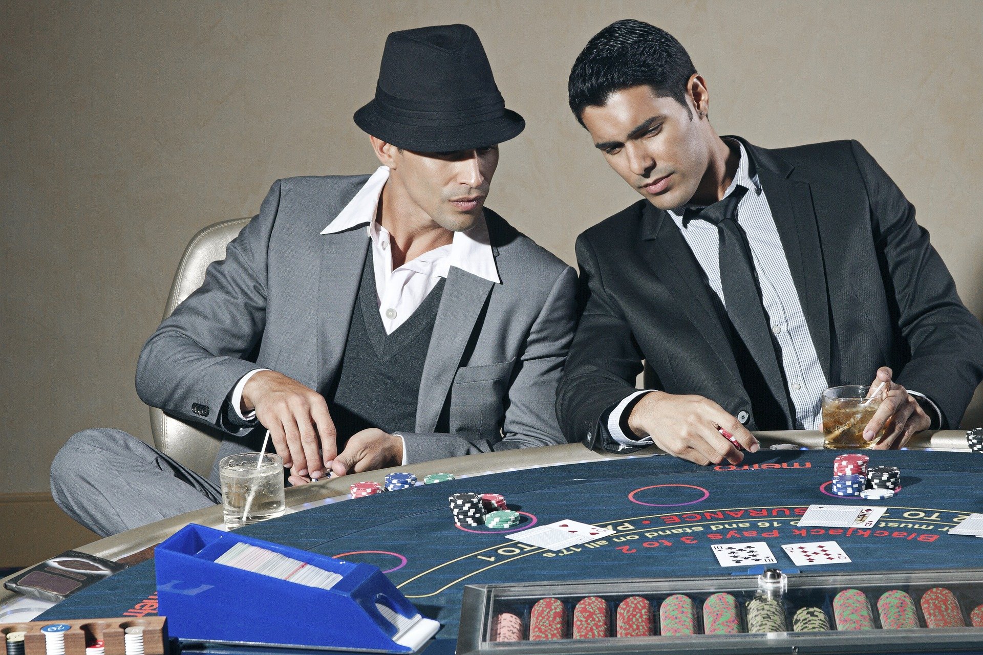 Spielszene am Blackjack Tisch mit zwei Männdern in Anzügen.