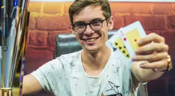 Aufnahme von Fedor Holz am Poker Spieltisch mit 2 Karten und Chips