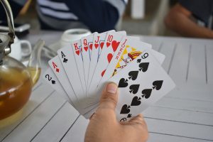 Spieler mit Karten in der Hand am Tisch