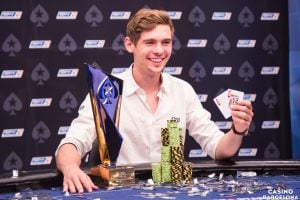 Fedor Holz posiert bei der EPT in Barcelona am Pokertisch mit der Starthand AK, seinem Pokal und seinem Chipstack