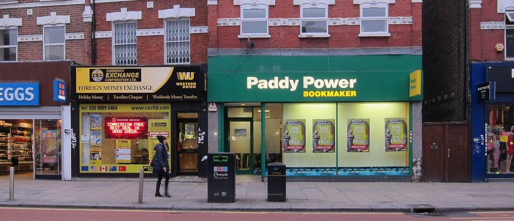Ein Laden des Buchmachers Paddy Power|||Mann mit Hut an einem FOBT-Spielautomaten|Zähler von Verlusten an FOBTS