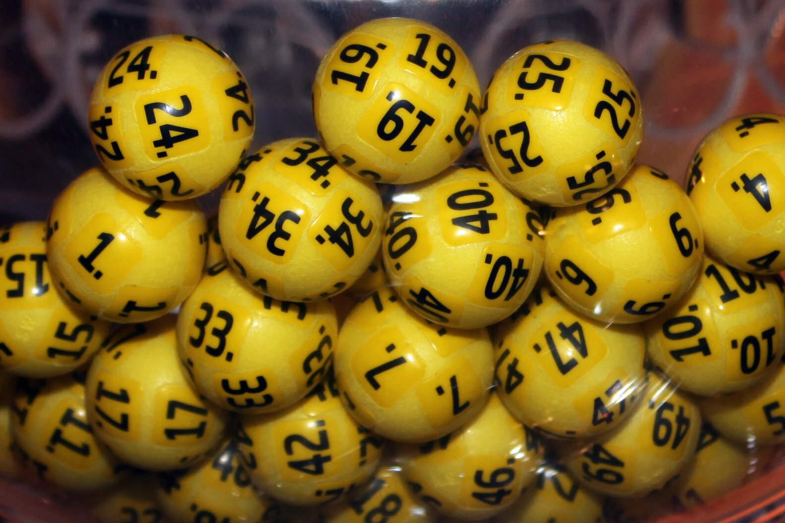 Lottokugeln in einer Trommel||Das Logo der Bildungs-Chancen-Lotterie