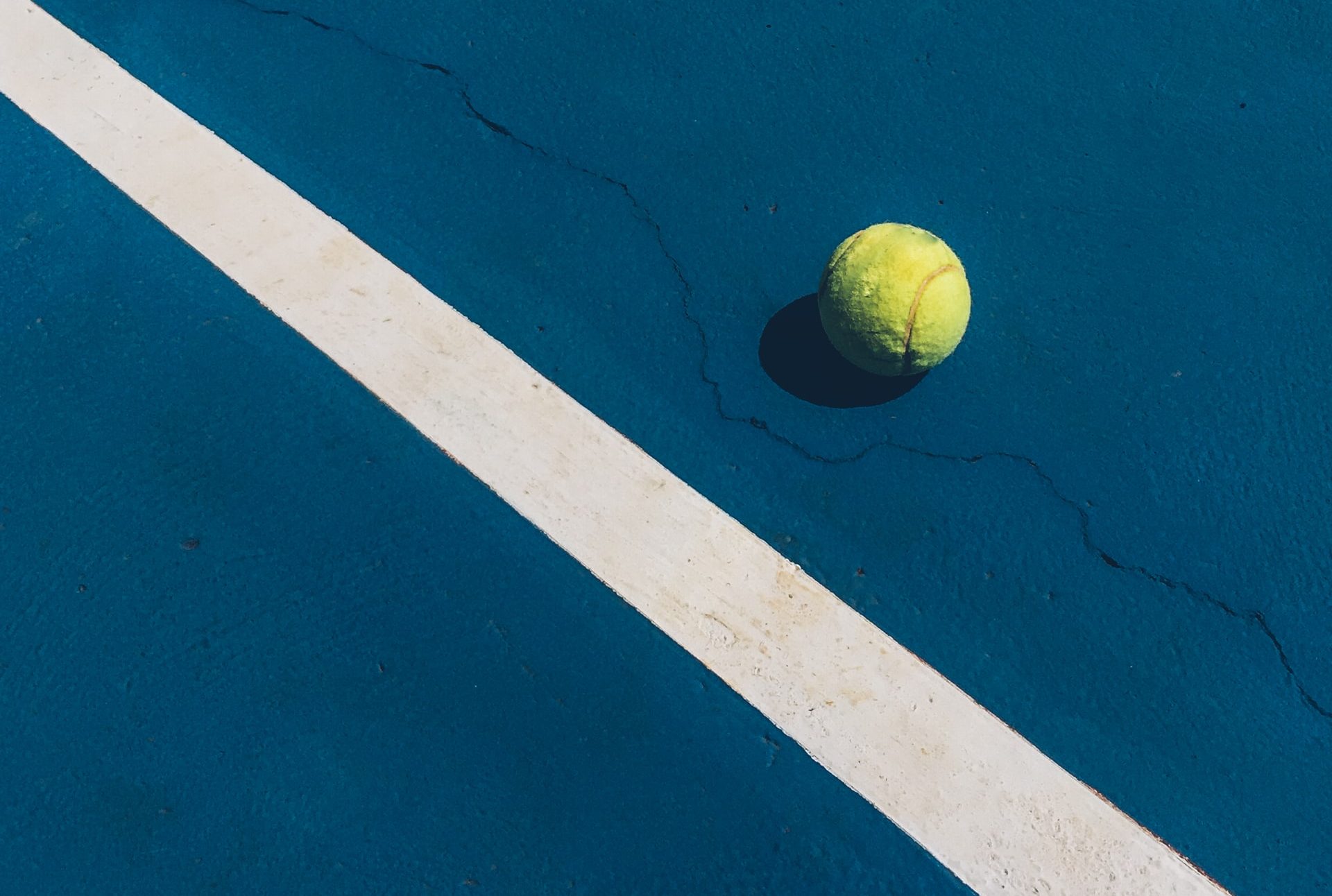 Tennisball auf blauem Platz