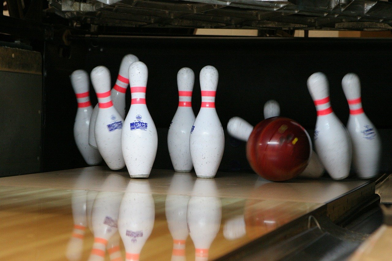 Bowling Kugel stürzt Kegel um