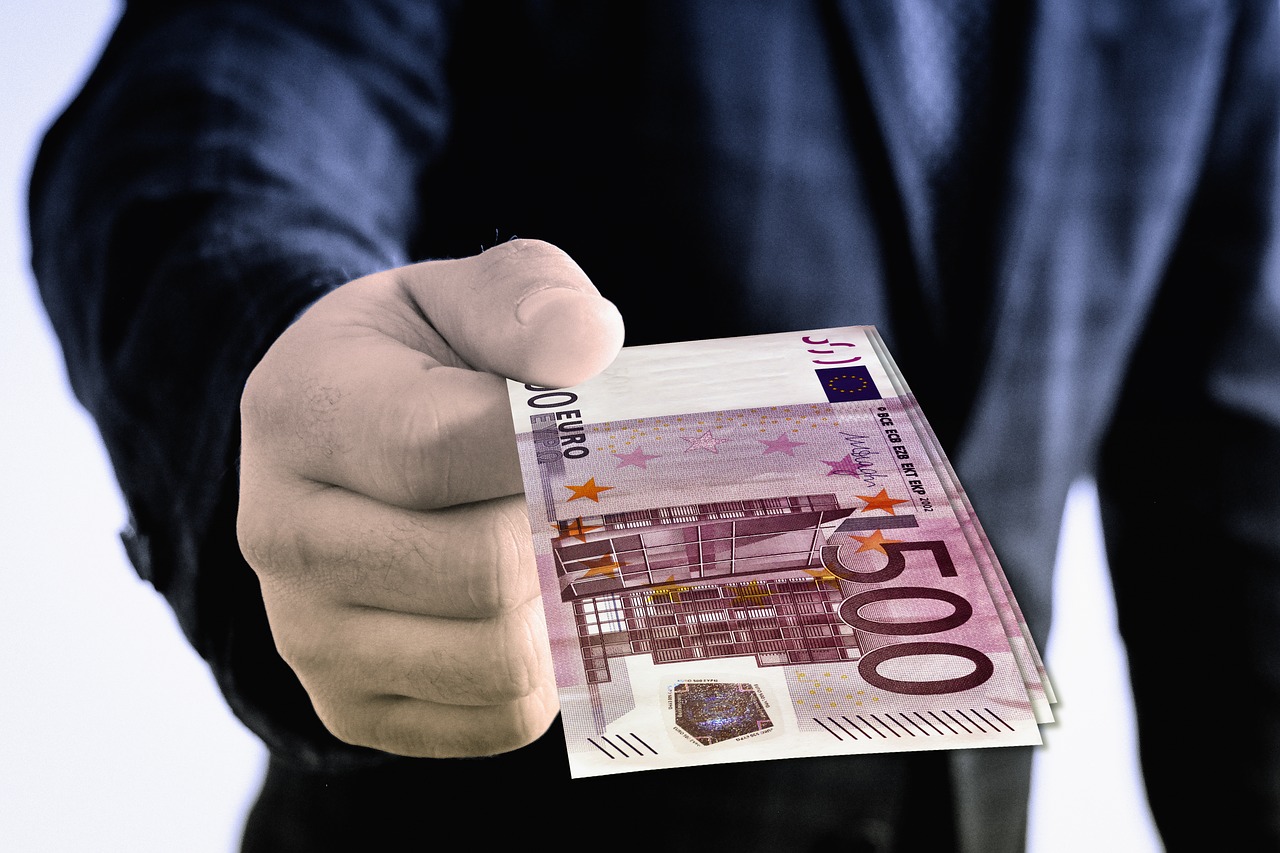 Mann übergibt 500 Euro Geldscheine