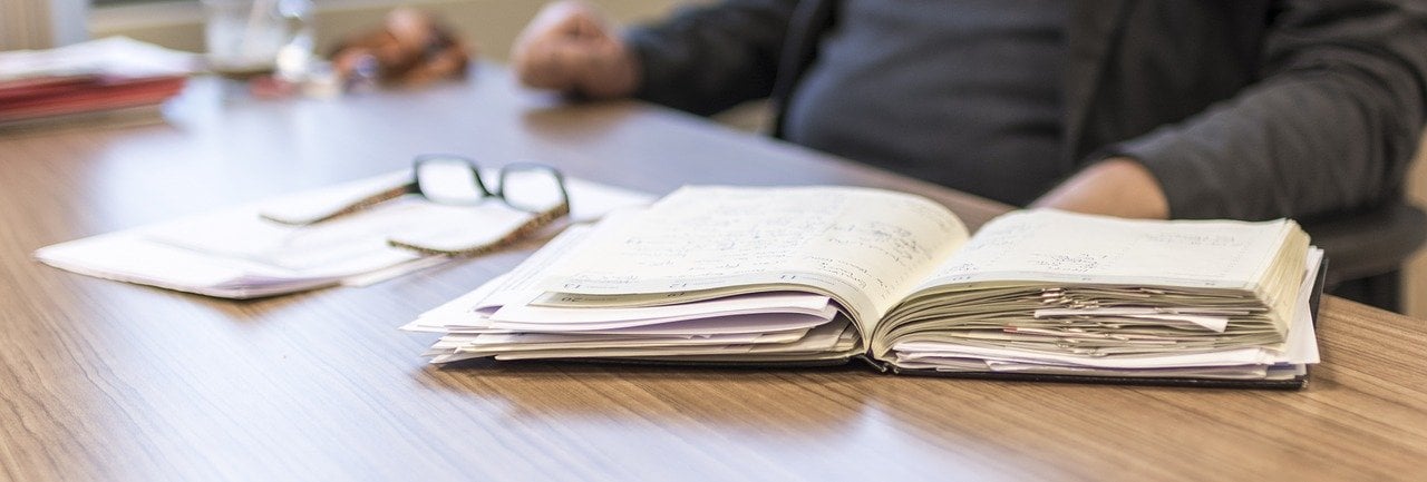 Buch mit Papieren auf Tisch