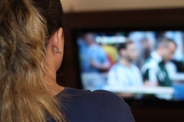 Frau vor Fernseher von hinten|Publikum im Sportstadion