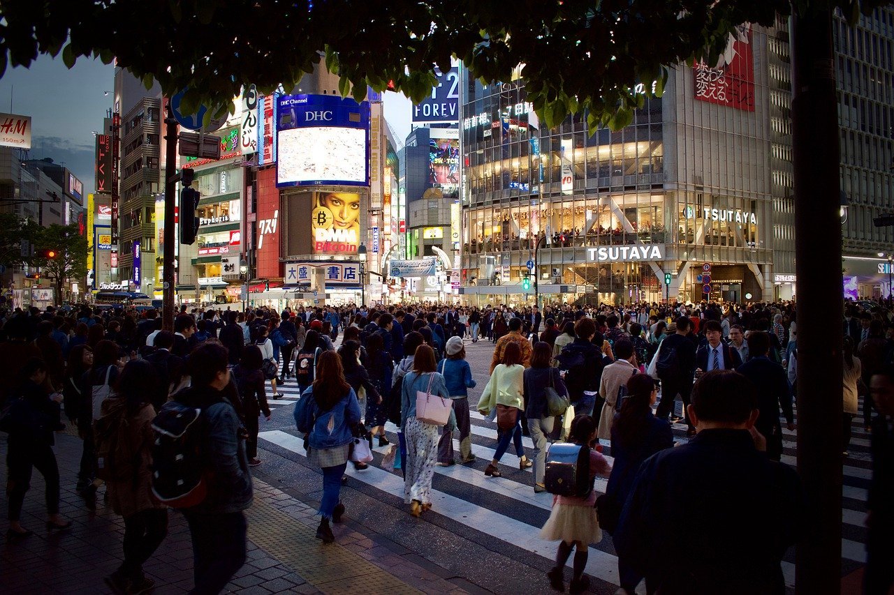 Eine Straße in Tokio|Spielchips in einer Hand|Die japanische Flagge in einer Hand