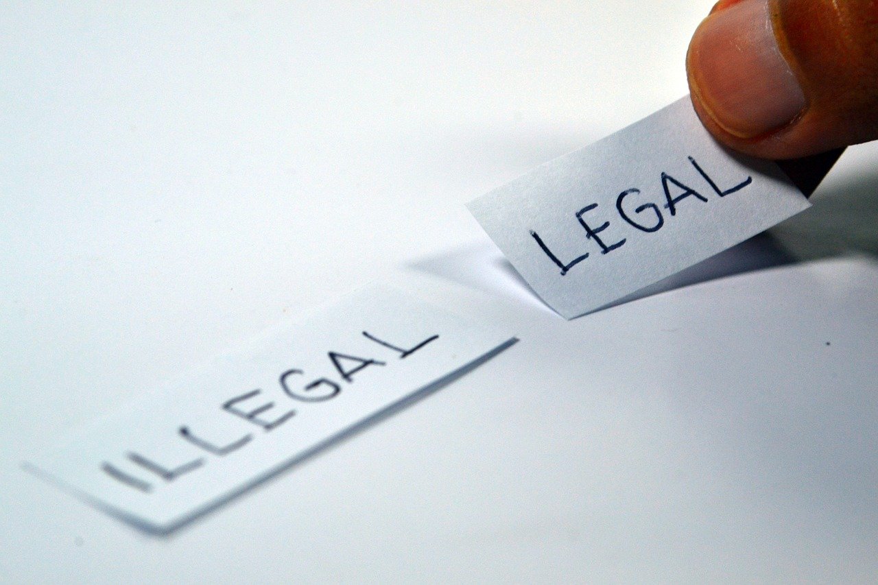 Zwei Zettel mit Schriftzügen legal und illegal