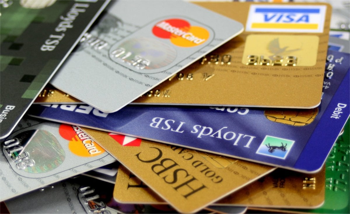 Kreditkarten übereinander|Hand mit Magnet zieht Geld in Laptop|Fixed-Odds-Betting-Terminal iPub