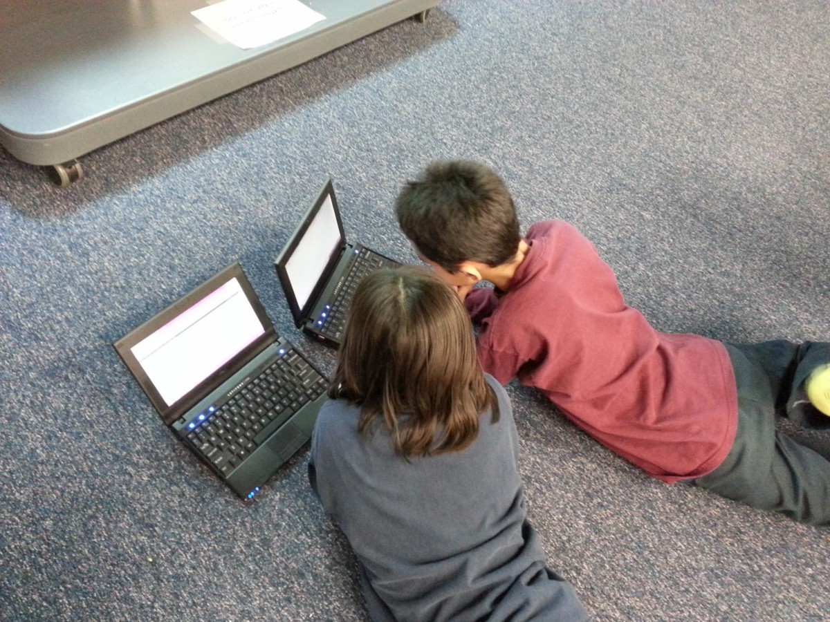 Kinder an Laptops auf dem Boden