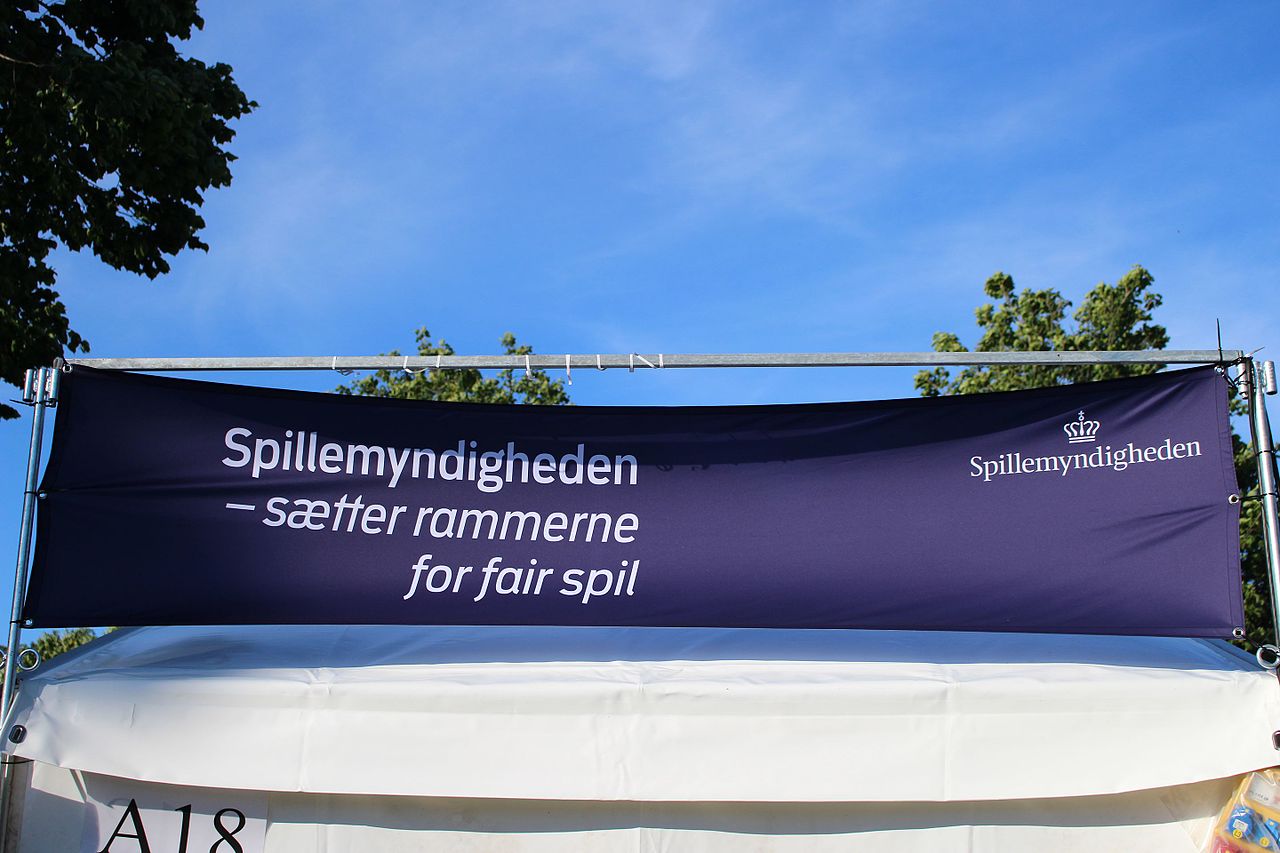 Spillemyndigheden Banner draußen|Figur hält Stop Schild