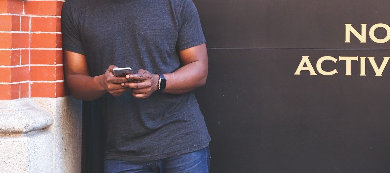 Ein Mann mit einem Handy in der Hand|Ein Mann mit Mobiltelefon in der Hand|Ein Mobilfunkturm