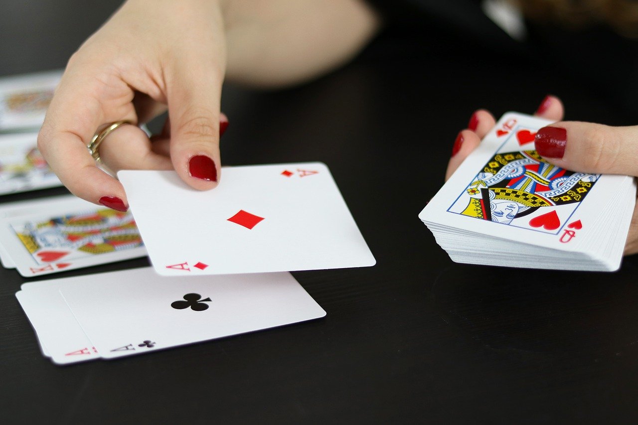 Eine Frau beim Kartenverteilen|Spielchips an einem Roulettetisch