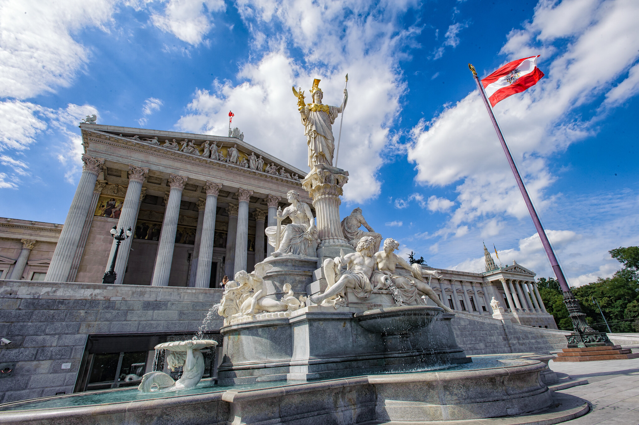 Österreichisches Parlament in Wien Statue blauer Himmel mit Wolken österreichische Flagge