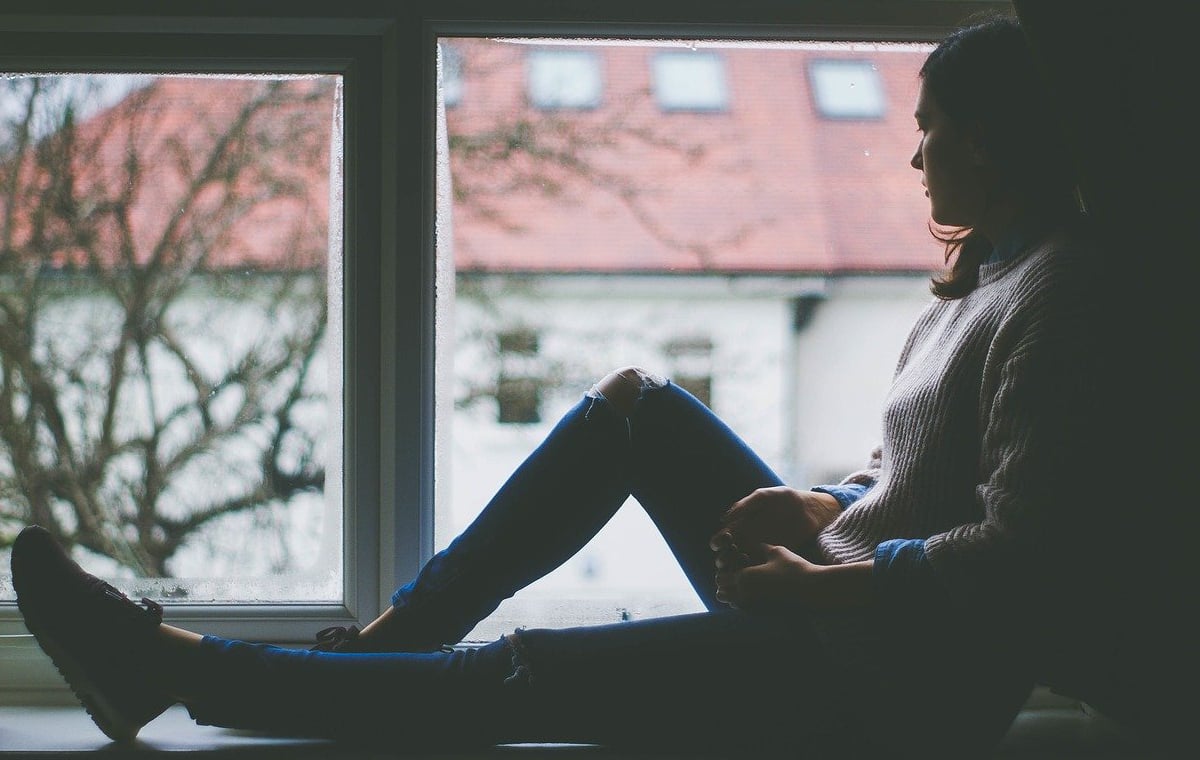 Frau im Fenster sitzend