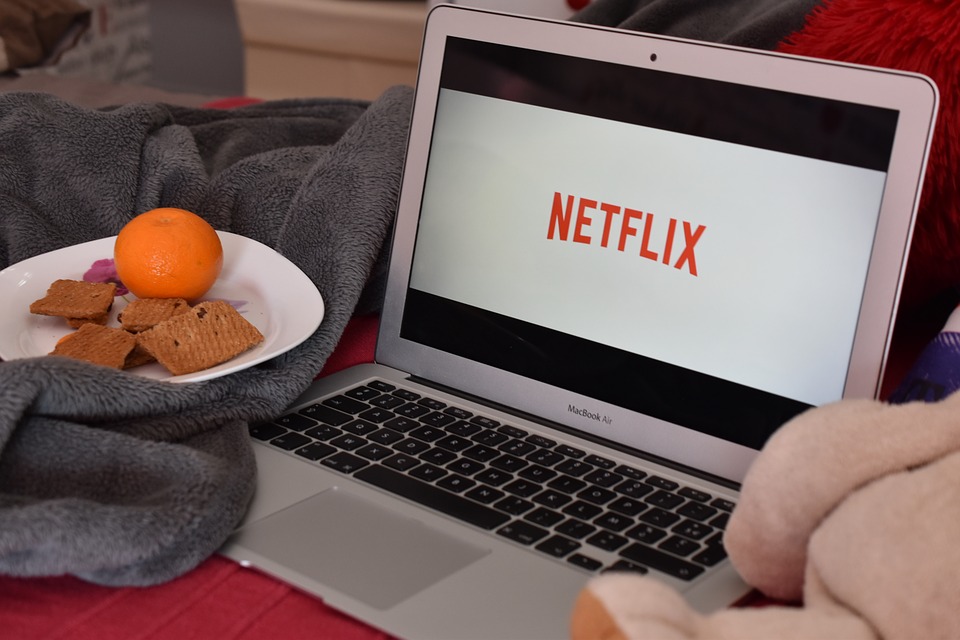 Laptop Netflix Teller mit Mandarine und Keksen