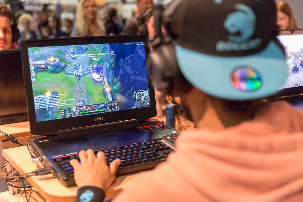 League of Legends auf Laptop Bildschirm Junge mit Cap spielt