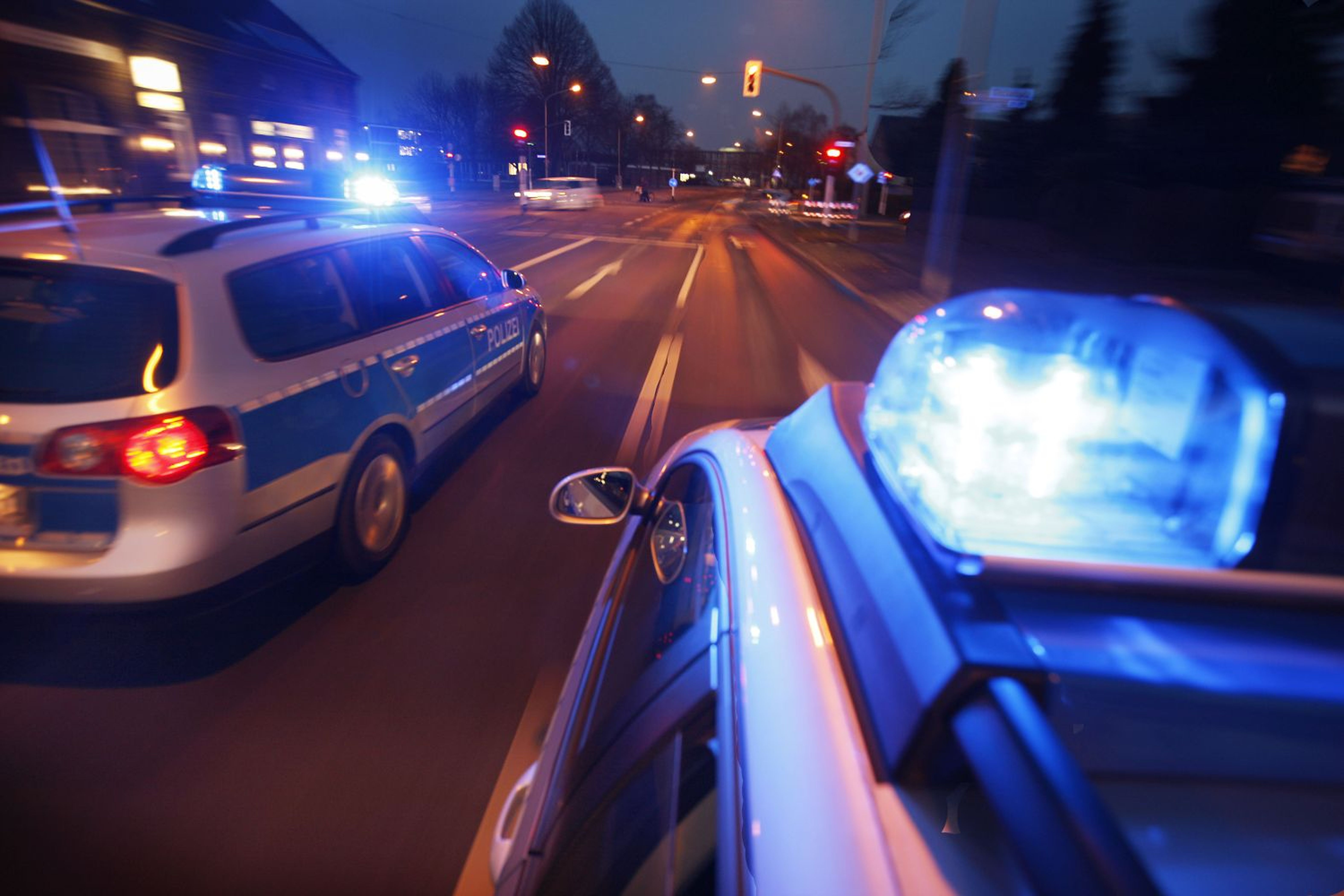 Zwei Polizeieinsatzwagen bei Nacht mit Blaulicht