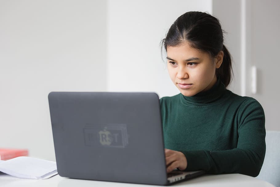 Junge Frau schaut auf einen Laptop